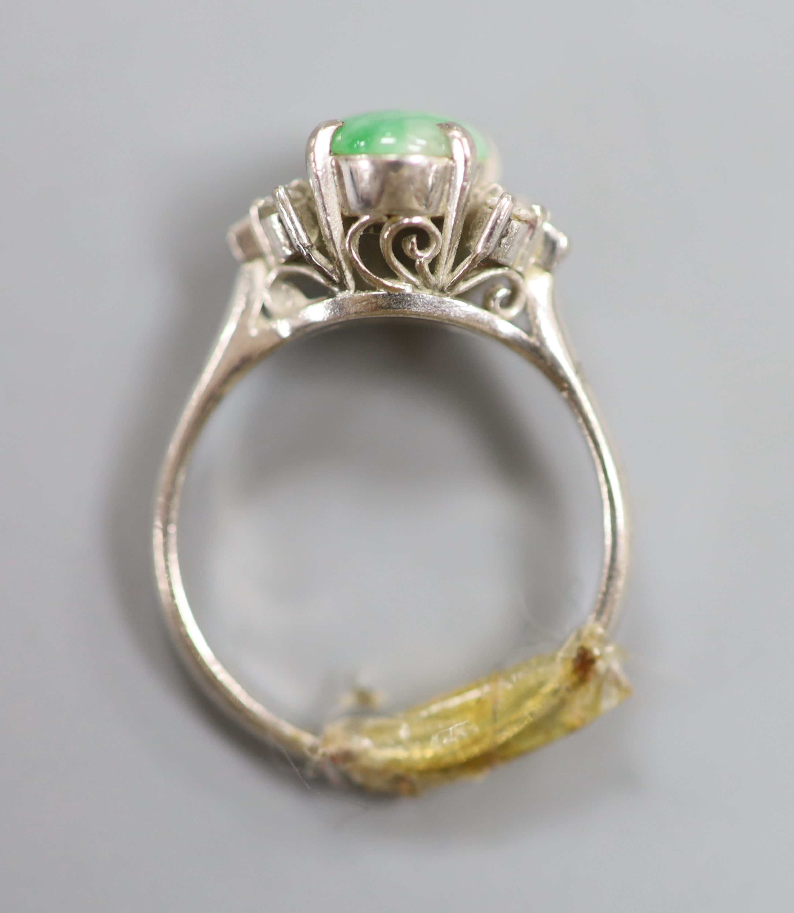 A 20th century 585 white metal, cabochon jade and diamond set five stone ring, size H/I, gross 3.6 grams.